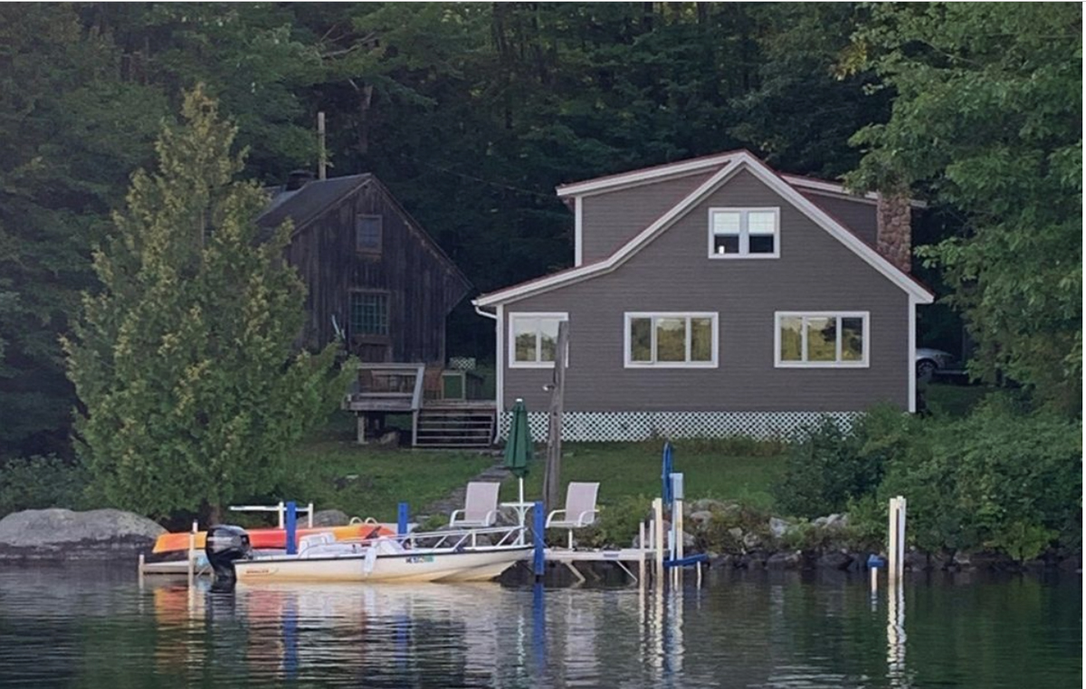 Paddle boat, dock with beige house in background
