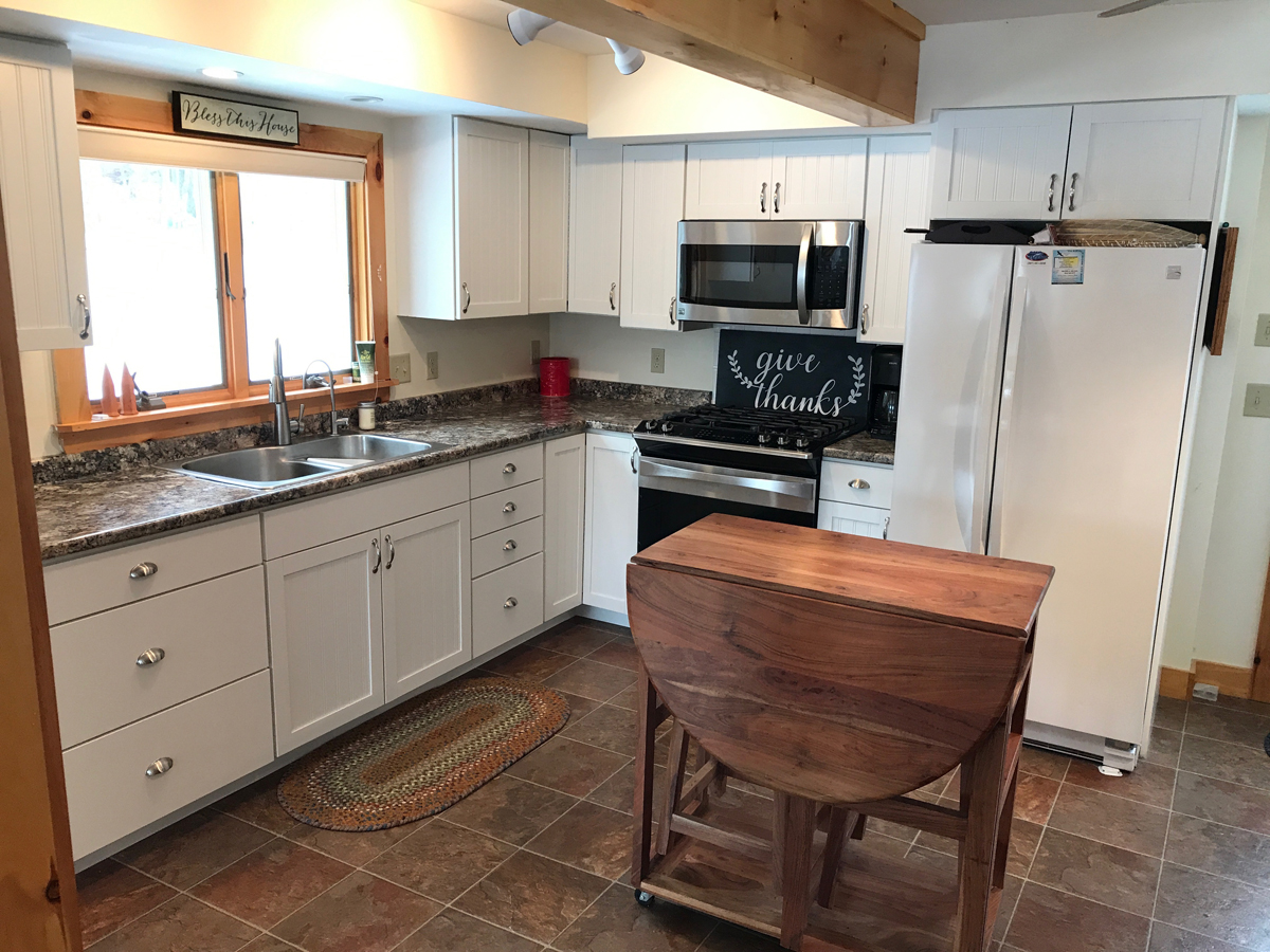 Sunny kitchen with white cabinets, steel applicances
