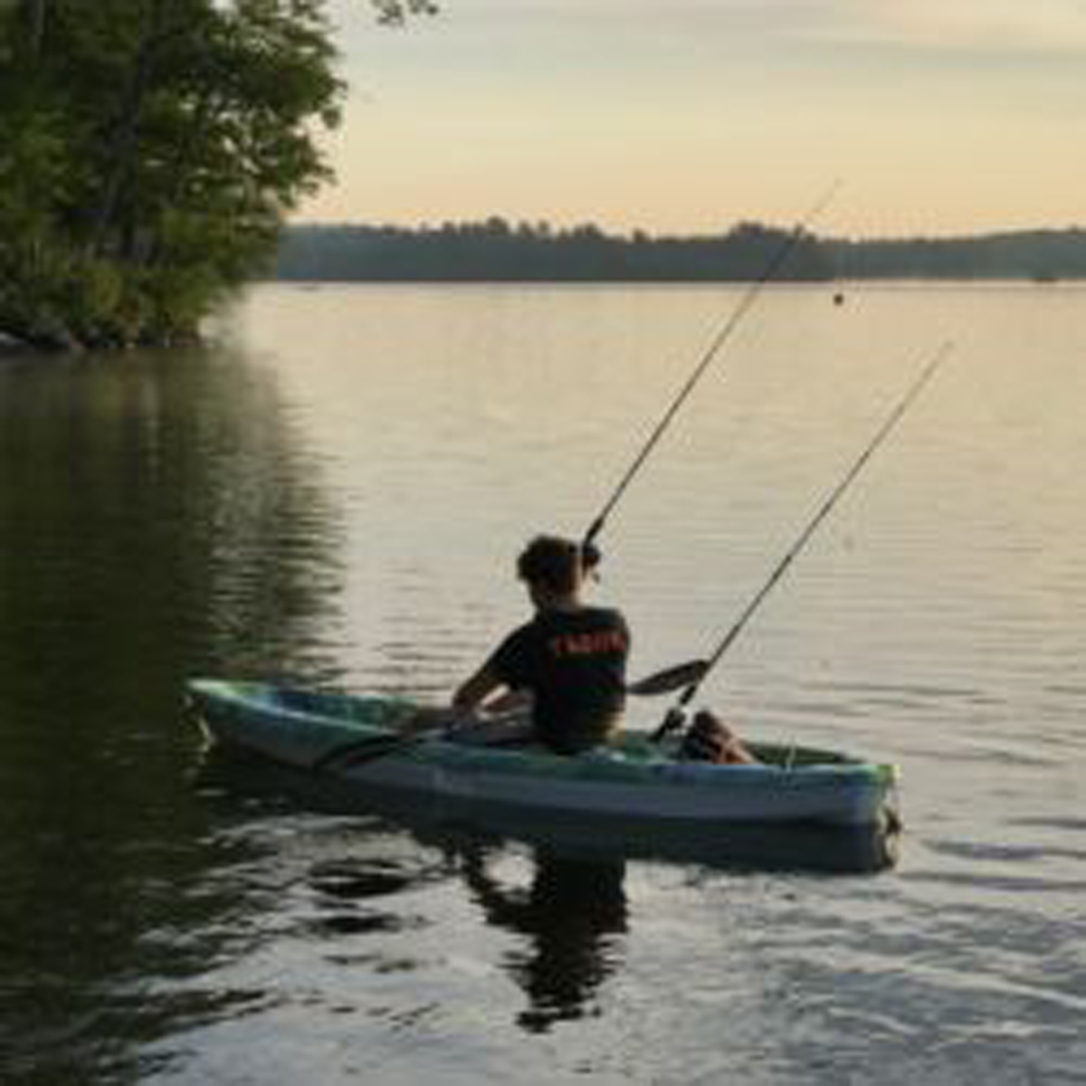 Boy fishing on canoe