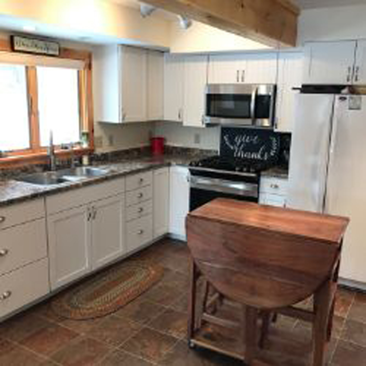 Kitchen with white cabinets and wooden folding table